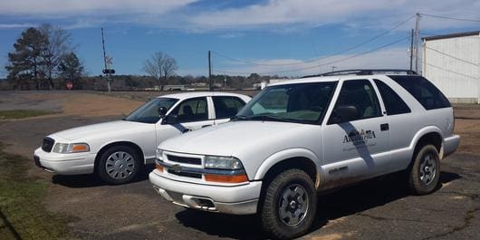 Two white trucks parked in a parking lot.
