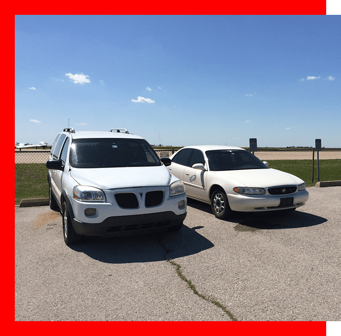 Two white cars parked in a parking lot.